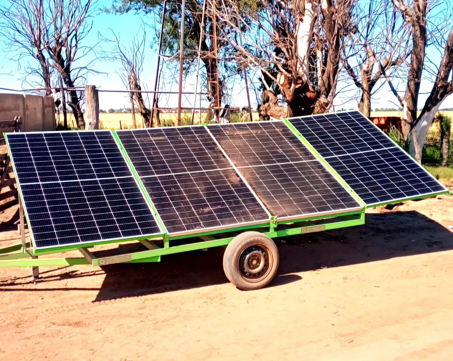 Carro con cuatro paneles solares montados sobre un trailer verde